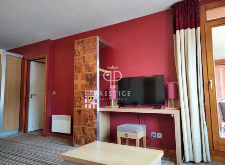 This property boasts a modern interior with a vibrant red accent wall, creating a warm and inviting atmosphere.