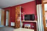 This property boasts a modern interior with a vibrant red accent wall, creating a warm and inviting atmosphere.