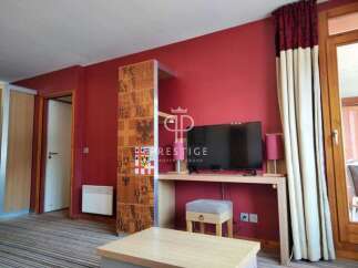 This property boasts a modern interior with a vibrant red accent wall, creating a warm and inviting atmosphere.