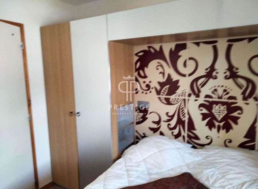 Discover a stylish bedroom featuring a unique patterned headboard and a cozy bed.