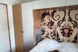 Discover a stylish bedroom featuring a unique patterned headboard and a cozy bed.