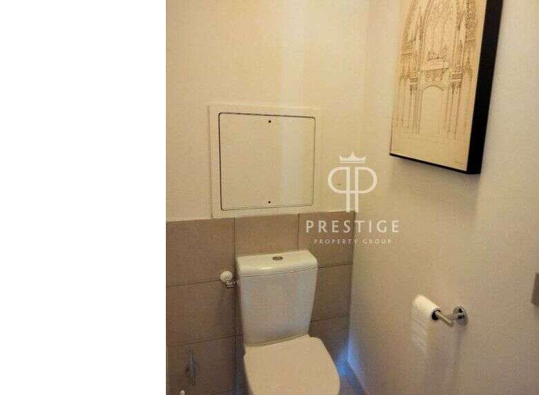 Discover a modern bathroom with a sleek toilet and stylish wall art.