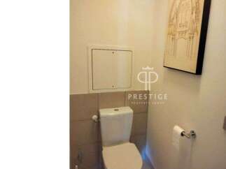 Discover a modern bathroom with a sleek toilet and stylish wall art.