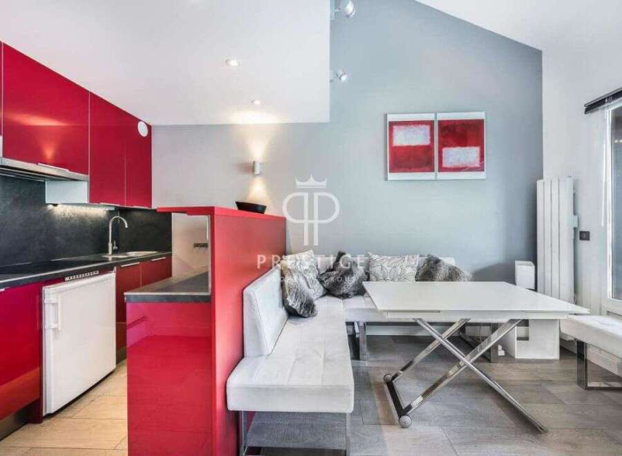 Modern kitchen with sleek red cabinetry and a contrasting black countertop.