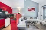 Modern kitchen with sleek red cabinetry and a contrasting black countertop.