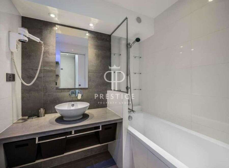 Modern bathroom design featuring a sleek vanity with a vessel sink and ample storage.