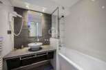 Modern bathroom design featuring a sleek vanity with a vessel sink and ample storage.