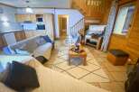 Cozy chalet living at its finest! This charming property boasts a warm and inviting interior with wooden accents throughout.