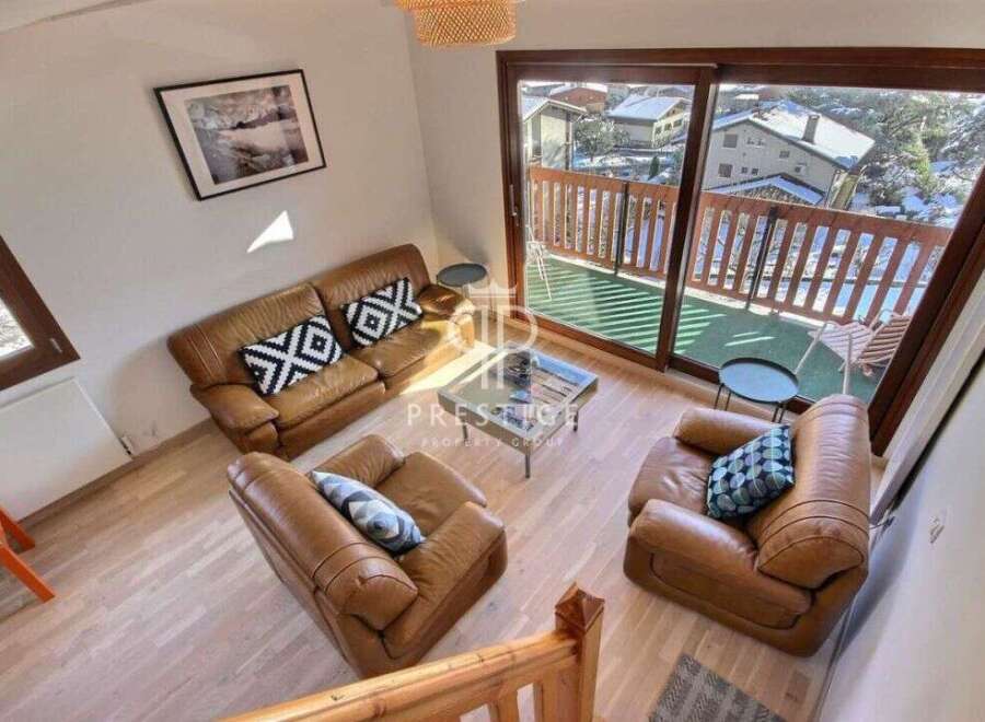 Discover a cozy living space with a stunning view! This property features a comfortable leather sofa and armchairs, perfect for relaxing.