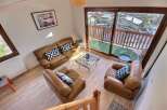 Discover a cozy living space with a stunning view! This property features a comfortable leather sofa and armchairs, perfect for relaxing.