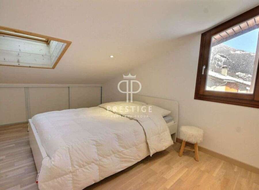 Discover a cozy bedroom retreat with a skylight and a stunning mountain view.