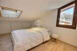 Discover a cozy bedroom retreat with a skylight and a stunning mountain view.