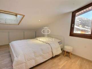 Discover a cozy bedroom retreat with a skylight and a stunning mountain view.