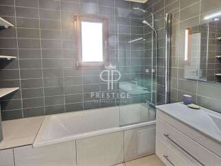 Discover a modern bathroom with sleek gray tiles and a luxurious bathtub.