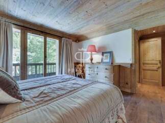 Discover the charm of this exquisite bedroom, featuring a cozy bed and elegant curtains.