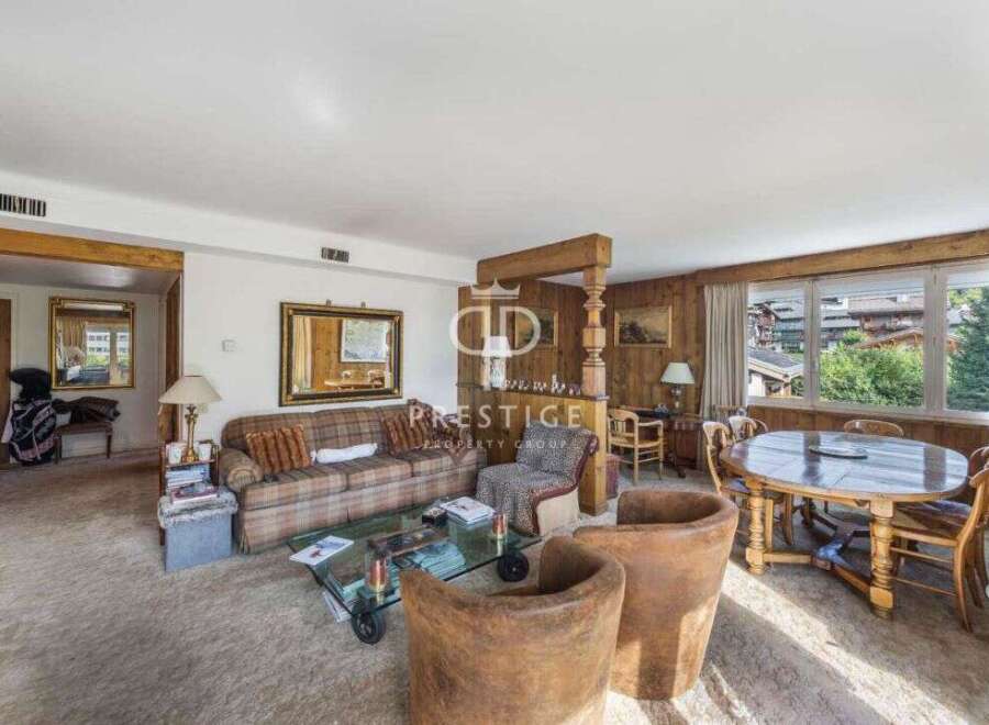 Discover the charm of this exquisite property, featuring a cozy living room with a plaid sofa and a stylish glass coffee table.