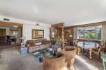 Discover the charm of this exquisite property, featuring a cozy living room with a plaid sofa and a stylish glass coffee table.
