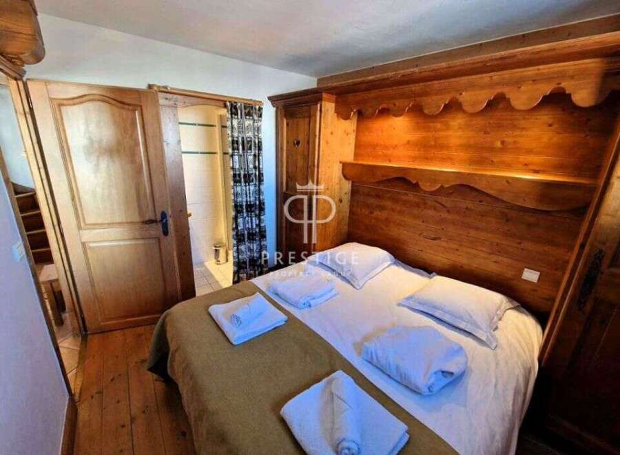 Discover a cozy bedroom with a charming wooden headboard and built-in storage.