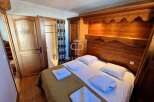 Discover a cozy bedroom with a charming wooden headboard and built-in storage.