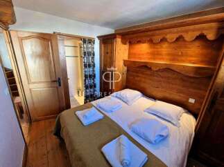 Discover a cozy bedroom with a charming wooden headboard and built-in storage.