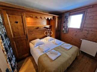Cozy bedroom with wooden paneling and a built-in wardrobe.