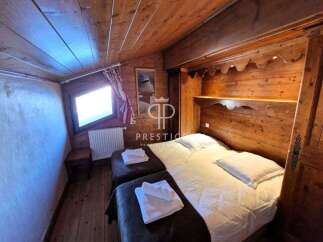 Cozy chalet bedroom featuring warm wooden accents and a charming, sloped ceiling.
