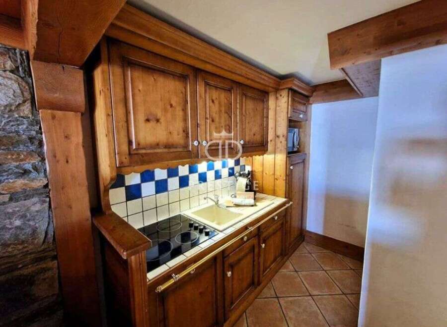 Discover the charm of this cozy kitchen, featuring warm wooden cabinetry and a classic tiled backsplash.