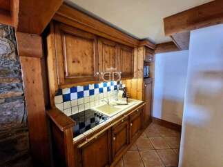 Discover the charm of this cozy kitchen, featuring warm wooden cabinetry and a classic tiled backsplash.