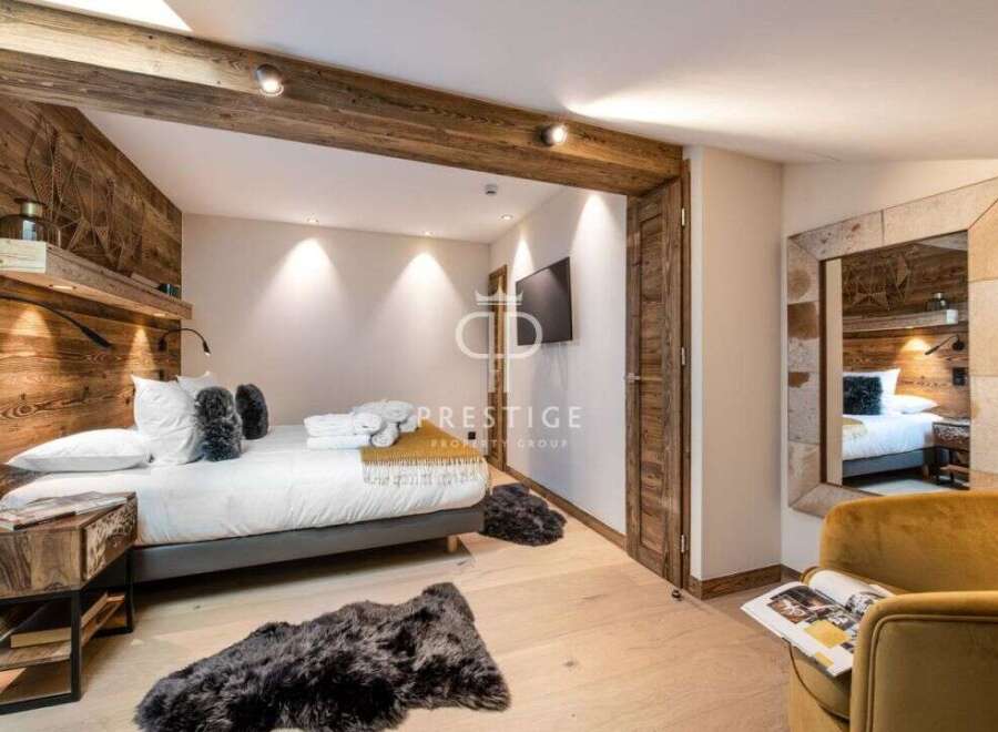 Experience luxury in this stunning bedroom featuring rustic wooden accents and a cozy ambiance.
