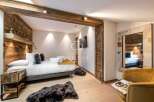 Experience luxury in this stunning bedroom featuring rustic wooden accents and a cozy ambiance.