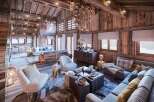 This stunning chalet boasts a spacious open-plan living area with exposed wooden beams and a cozy fireplace, perfect for relaxing after a day on the slopes.
