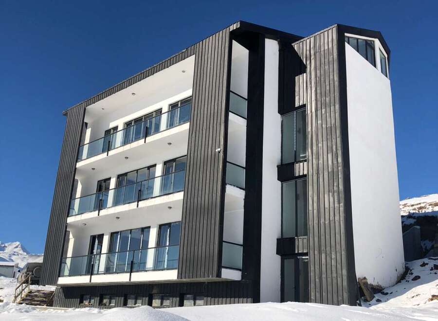 Discover a modern architectural marvel nestled in a snowy landscape.