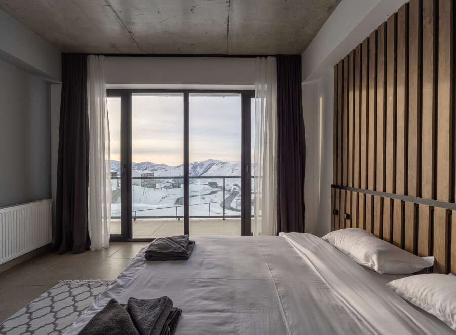 Experience breathtaking mountain views from this luxurious bedroom.