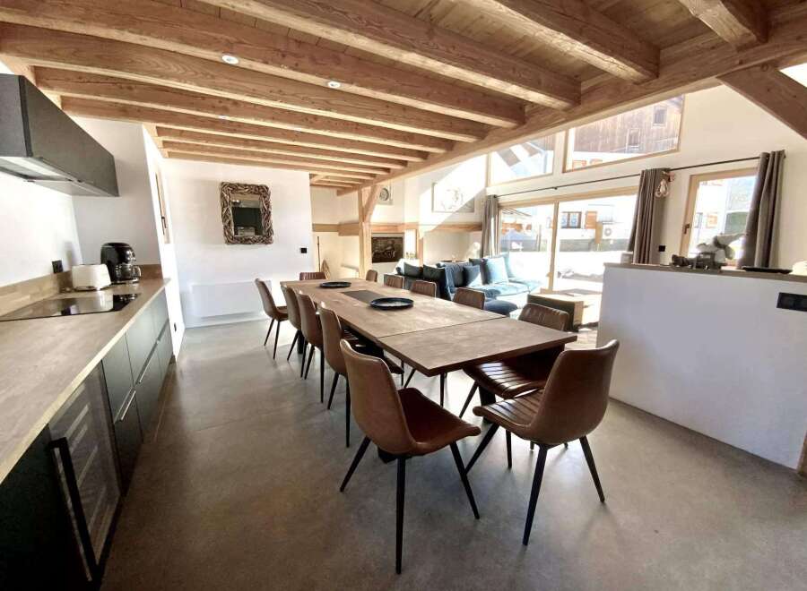 This stunning chalet boasts a spacious open-plan living area with floor-to-ceiling windows offering breathtaking views.