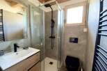 Modern bathroom with walk-in shower, sleek fixtures, and wooden vanity.
