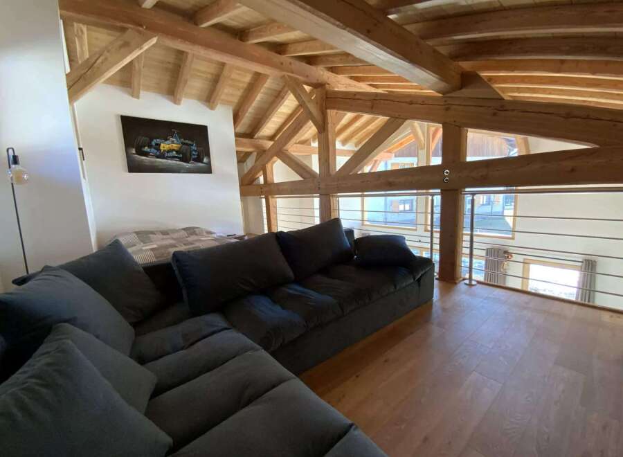 Relax in this stunning chalet featuring a spacious open-plan living area with a comfortable sectional sofa and breathtaking views.