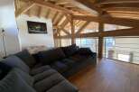 Relax in this stunning chalet featuring a spacious open-plan living area with a comfortable sectional sofa and breathtaking views.