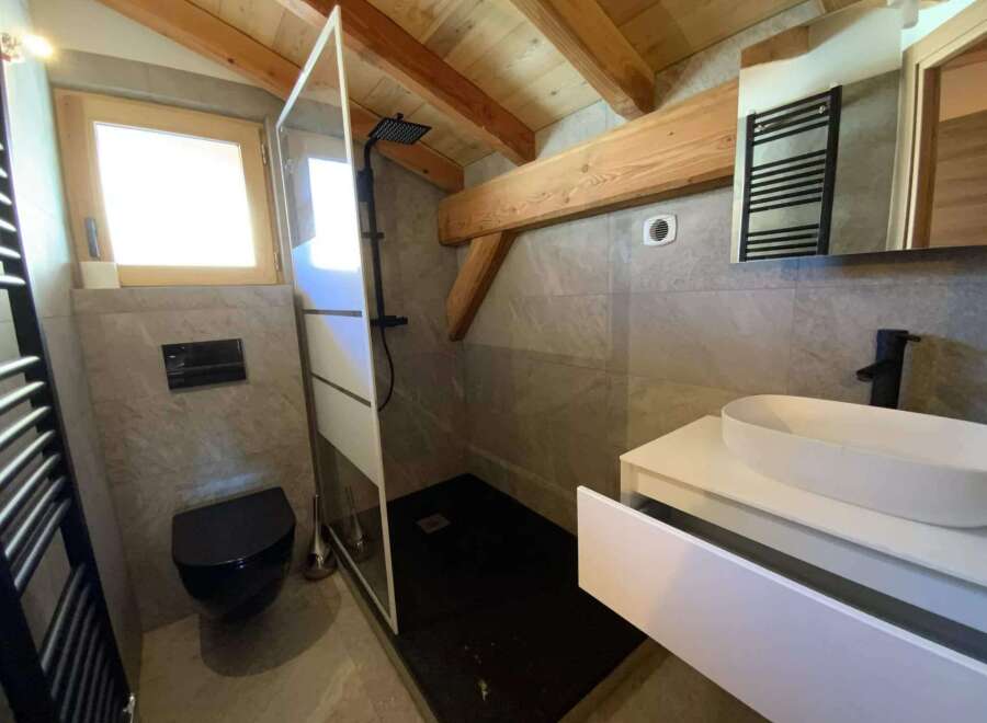 This stunning bathroom boasts a modern design with a walk-in shower, sleek black fixtures, and a floating vanity with ample storage.