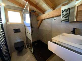 This stunning bathroom boasts a modern design with a walk-in shower, sleek black fixtures, and a floating vanity with ample storage.