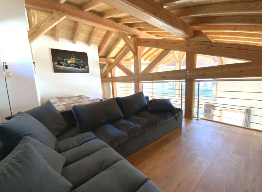 Relax in this stunning chalet featuring a spacious open-plan living area with a comfortable sectional sofa and breathtaking views.