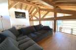 Relax in this stunning chalet featuring a spacious open-plan living area with a comfortable sectional sofa and breathtaking views.