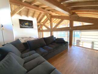 Relax in this stunning chalet featuring a spacious open-plan living area with a comfortable sectional sofa and breathtaking views.