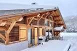 This stunning chalet boasts a beautiful wooden exterior, large windows offering breathtaking views, and a spacious deck perfect for outdoor entertaining.