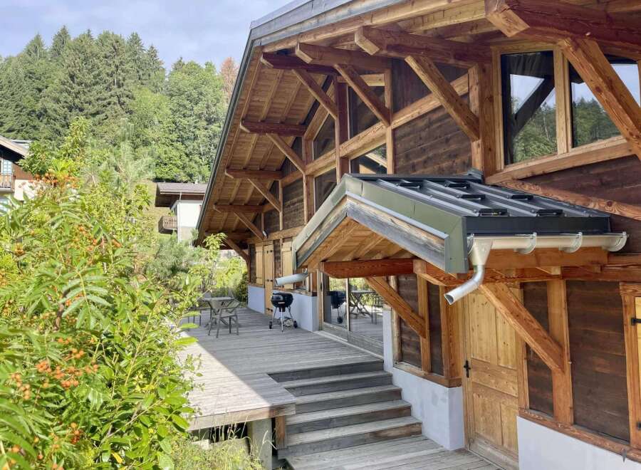 This stunning chalet boasts a spacious deck perfect for outdoor entertaining, complete with a built-in grill.