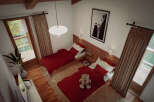 Cozy chalet bedroom with twin beds, red plaid bedding, and a teddy bear.
