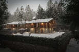 Luxury chalet nestled in a snowy forest, offering breathtaking views and serene ambiance.