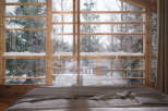 Wake up to breathtaking views of a snow-covered forest from this cozy bedroom.