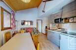 Cozy studio apartment in the French Alps with a fully equipped kitchenette, including a microwave, stovetop, and refrigerator.