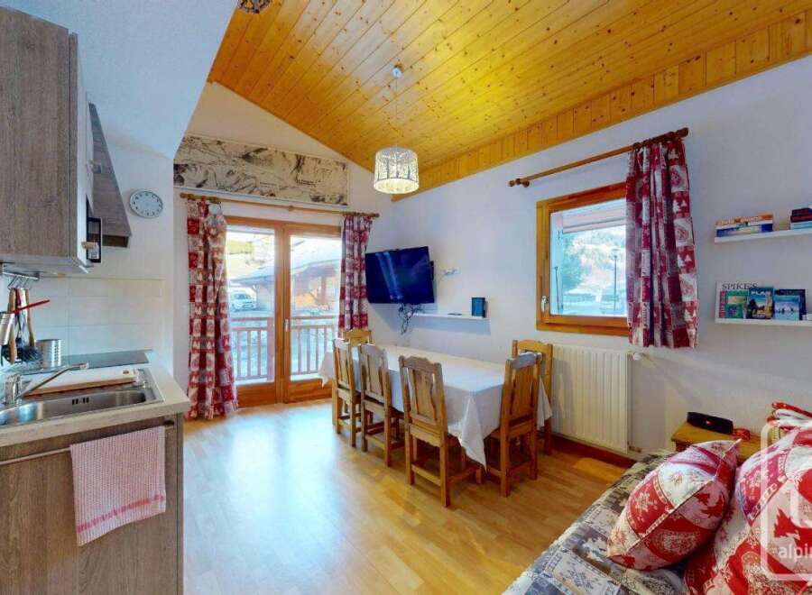 Cozy studio apartment in the French Alps with a fully equipped kitchenette, dining area, and comfortable living space.