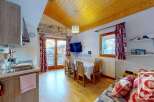 Cozy studio apartment in the French Alps with a fully equipped kitchenette, dining area, and comfortable living space.